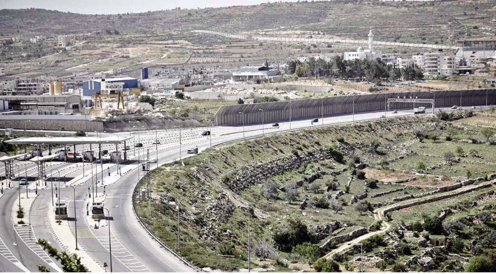 A section of the 4.35-kilometer-long wall being built by Israel on the lands of Al-Khader. Once completed, it will separate the town of Al-Khader from 68 percent of its lands and properties. The Israeli military checkpoint that can be seen on the left was constructed on the lands of Al-Khader. No Palestinian residents of Al-Khader are allowed to pass through this checkpoint, even if they obtained a military permit. ©Patrick Kruse/OPGAI.