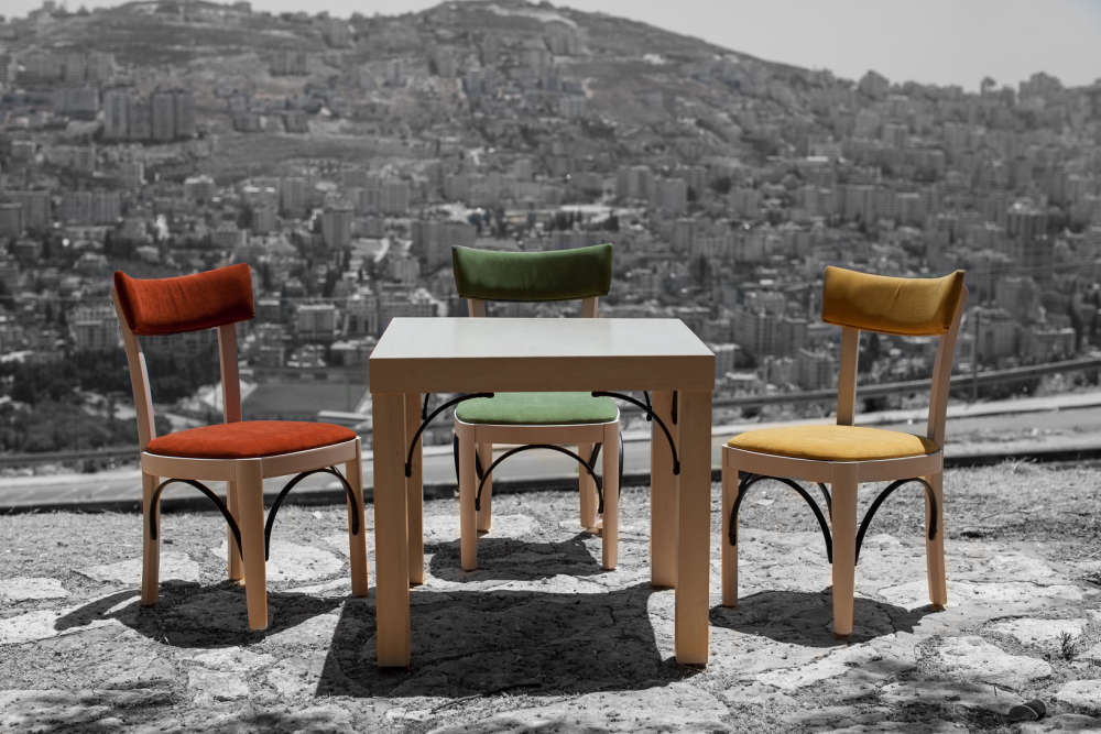 A set of table and chairs from the Khan Al-Wakaleh Collection. In the background, the city of Nablus. Photo credit: UNIDO Palestine – Ashraf Dowani.