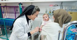 Caritas Baby Hospital Nursing Director, Sister Lucia Corradin, with a mother and her baby in the pediatric inpatient ward. Photo by Meinrad Schade.